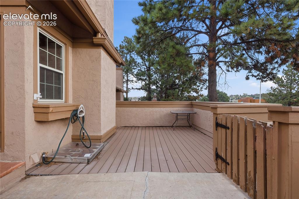 Image 6 of 35: Exterior patio featuring composite decking, stucco siding, and a privacy fe