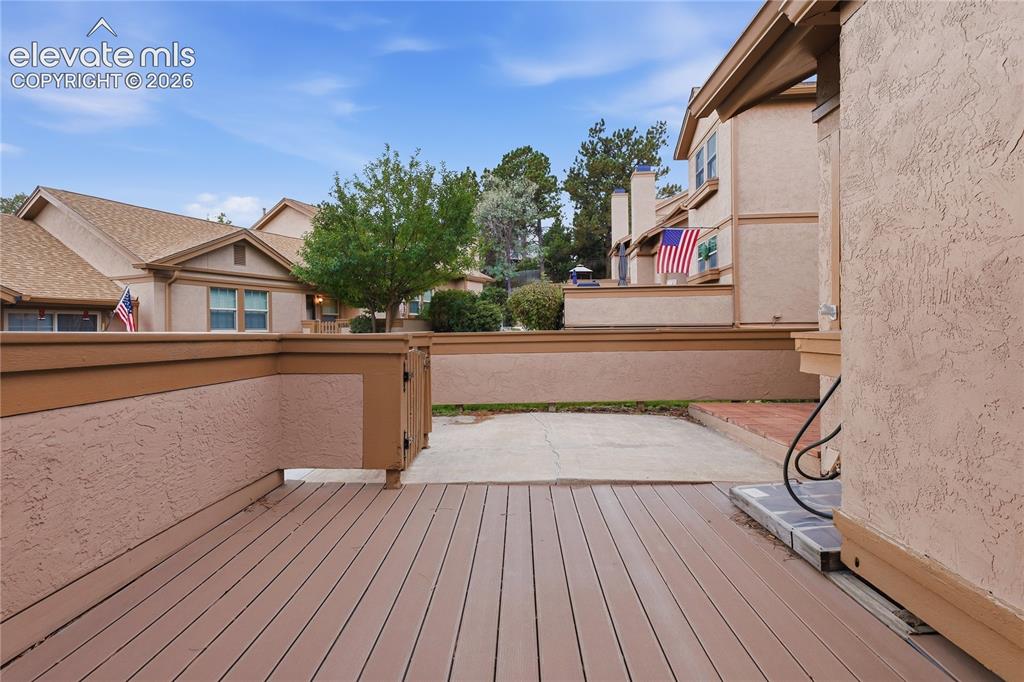 Image 8 of 35: Spacious outdoor deck featuring composite decking and a stucco wall with a 
