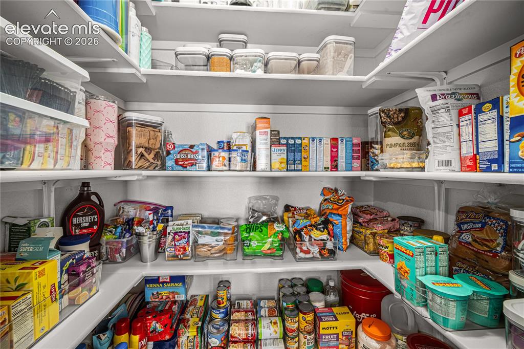 Image 10 of 50: Corner pantry featuring multiple levels of white shelving