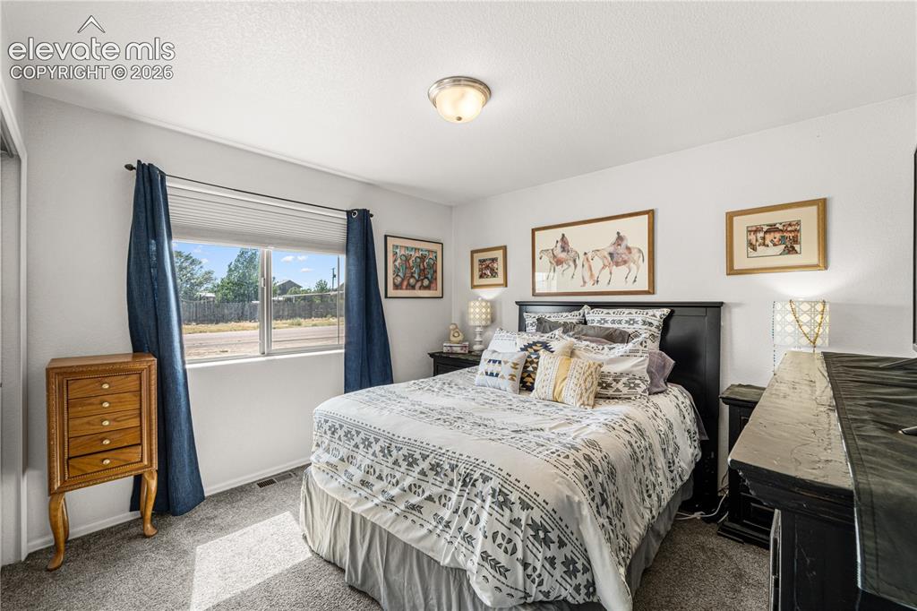 Image 21 of 50: Bedroom featuring a double-paned window, neutral wall paint, and gray carpe