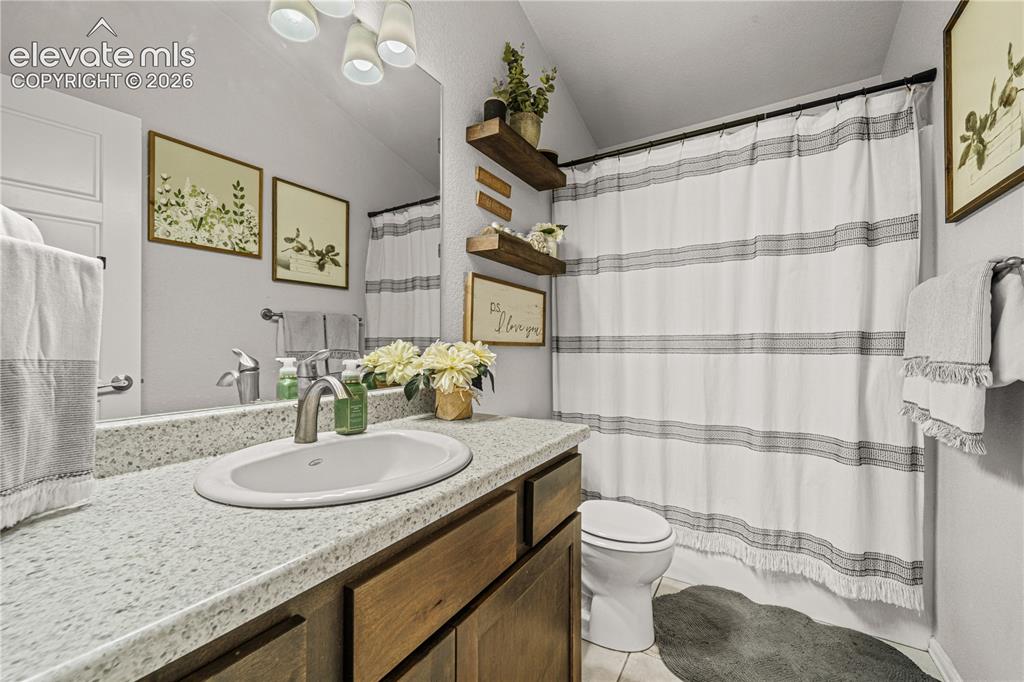 Image 22 of 50: Bathroom featuring a rectangular mirror, a light-colored countertop with an
