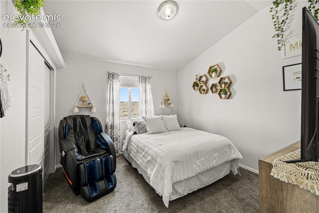 Image 24 of 50: Room featuring a vaulted ceiling and window with a distant landscape visibl