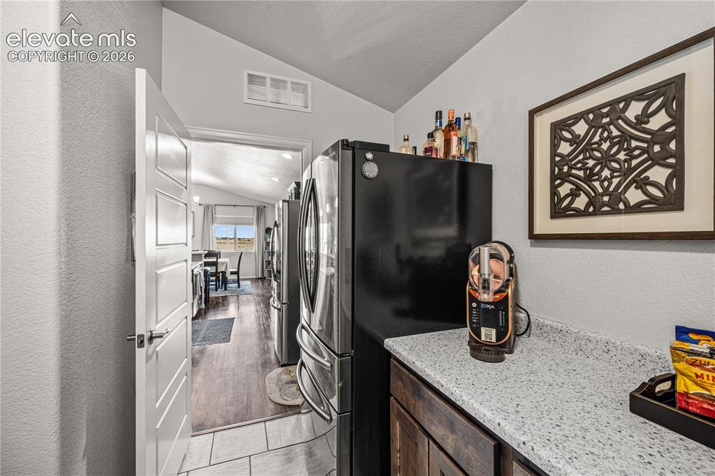 Image 27 of 50: Kitchenette featuring a light speckled countertop, dark wood-finish cabinet