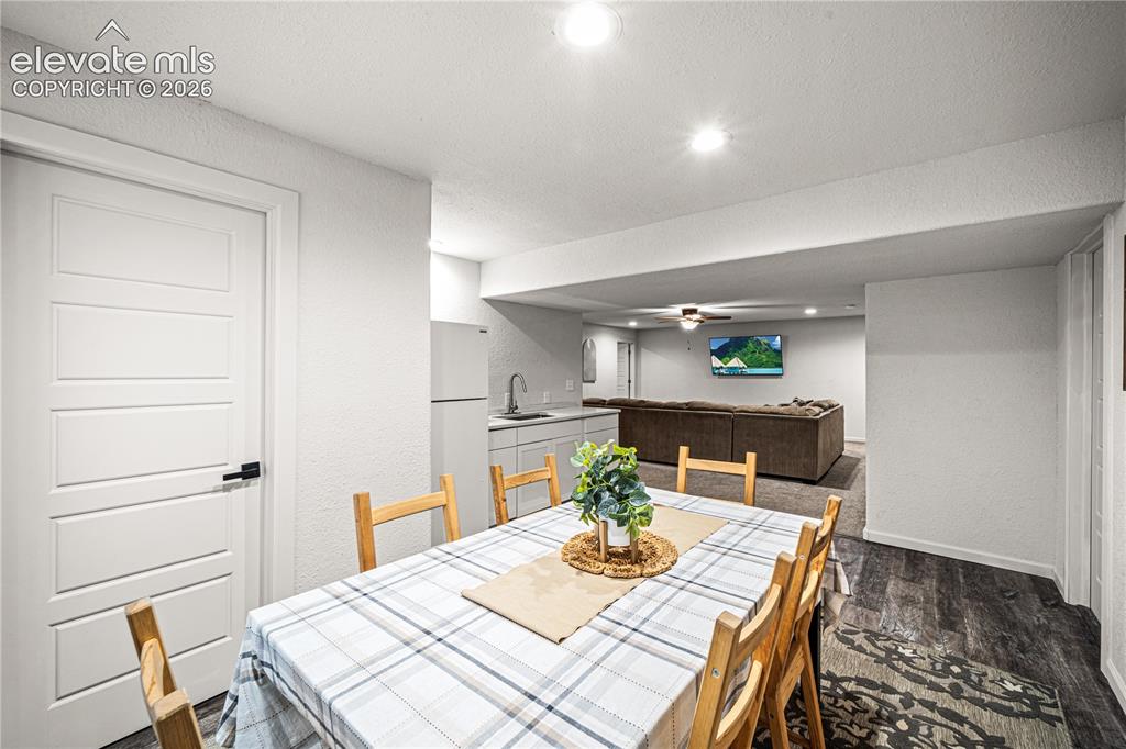 Image 33 of 50: Finished basement with distinct areas featuring recessed lighting, a modern