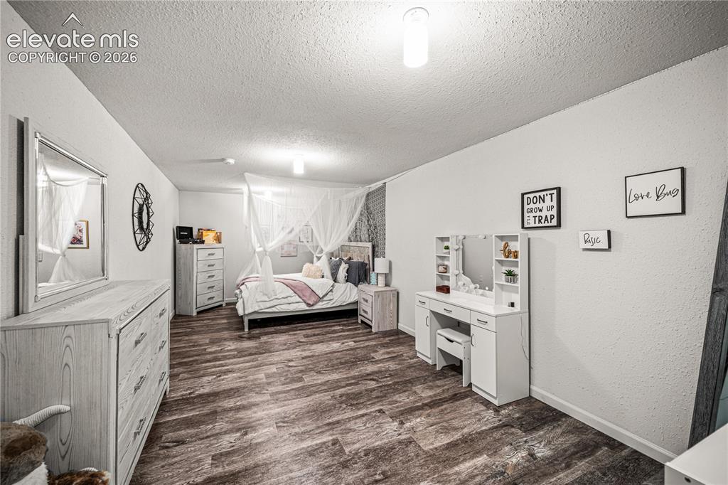 Image 35 of 50: Spacious interior room featuring wood-finish flooring and light-toned walls