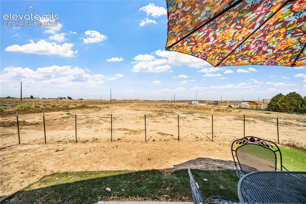Image 44 of 50: Expansive outdoor space featuring a large, partially fenced yard with open 
