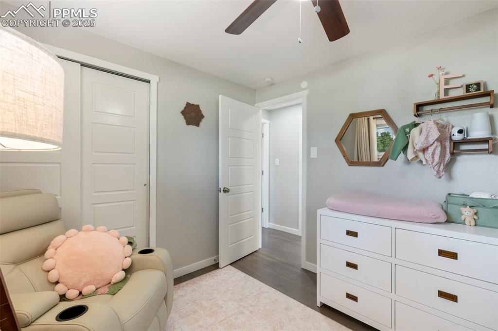 Image 17 of 37: Living area with ceiling fan and dark wood-type flooring