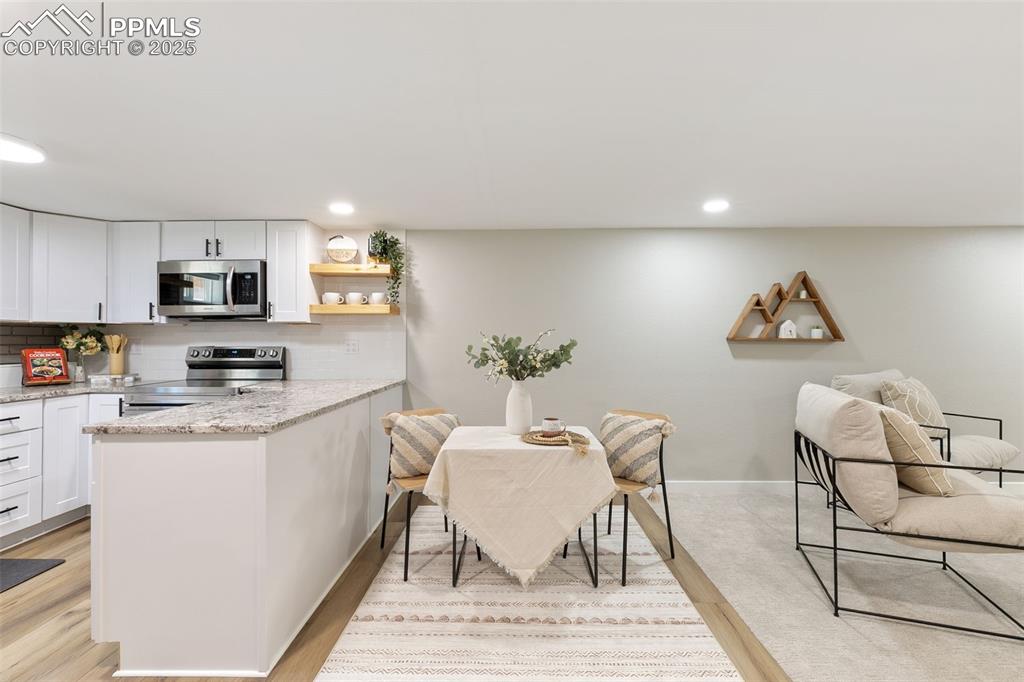 Image 22 of 37: Kitchen with tasteful backsplash, open shelves, stainless steel appliances,