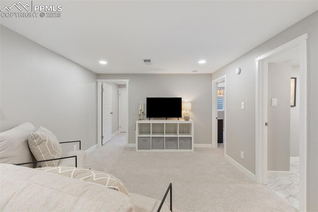 Image 25 of 37: Living room with light carpet and recessed lighting