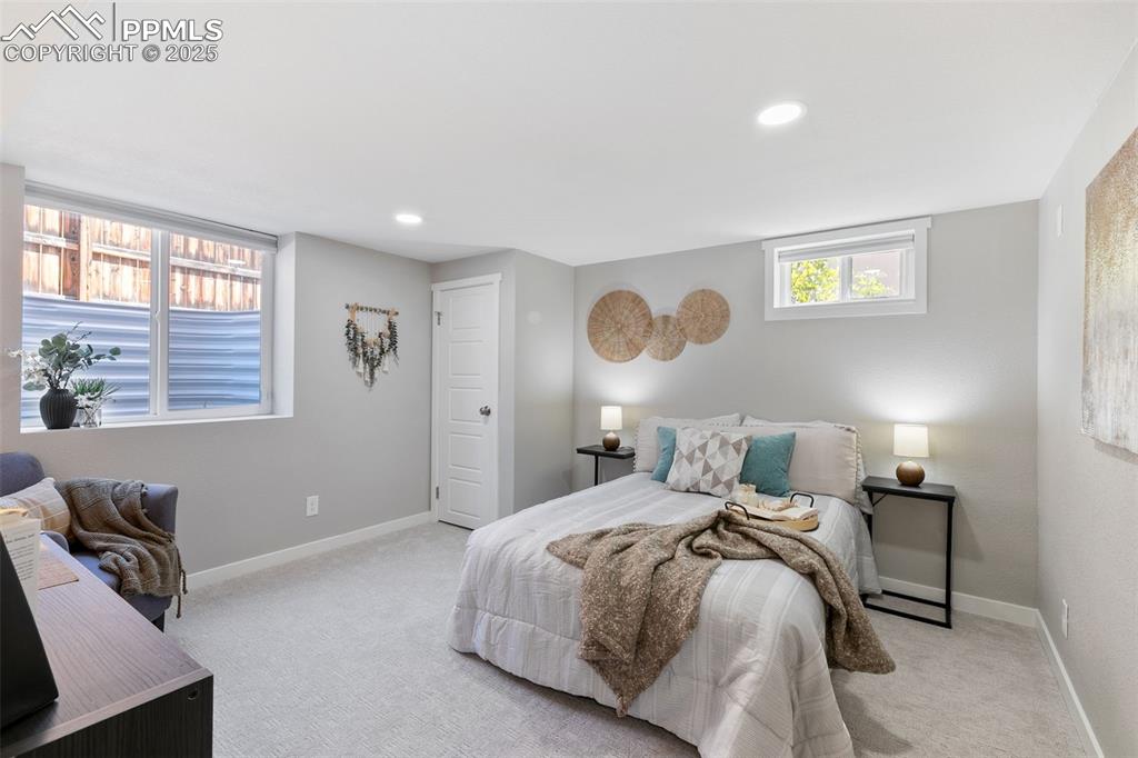 Image 27 of 37: Bedroom with light colored carpet and recessed lighting