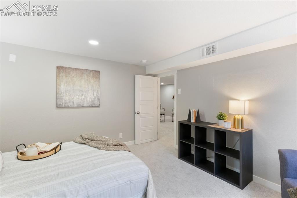 Image 28 of 37: Bedroom with light carpet and recessed lighting