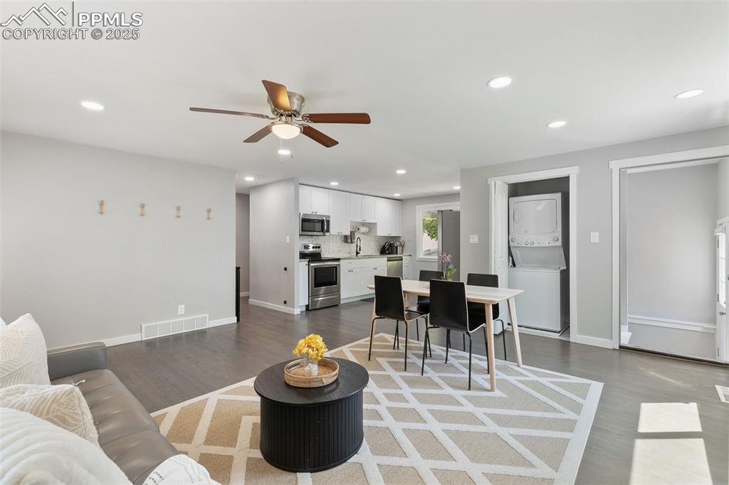 Image 7 of 37: Living room with recessed lighting, dark wood-style floors, stacked washer