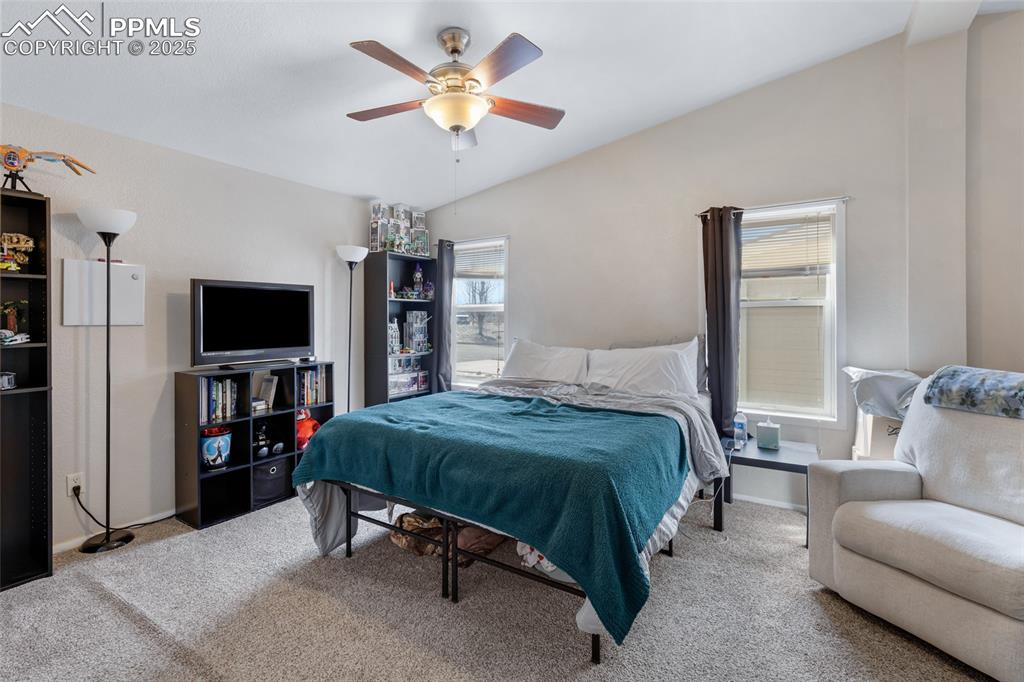 Image 16 of 24: Carpeted bedroom featuring a ceiling fan and lofted ceiling
