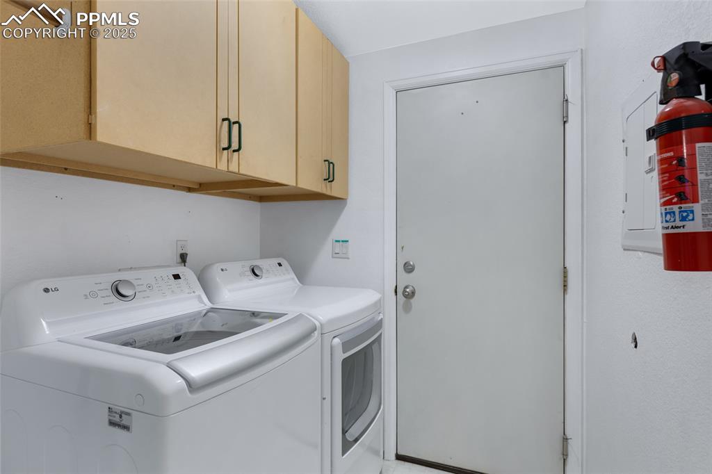 Image 20 of 24: Laundry room featuring independent washer and dryer, cabinet space, and ele