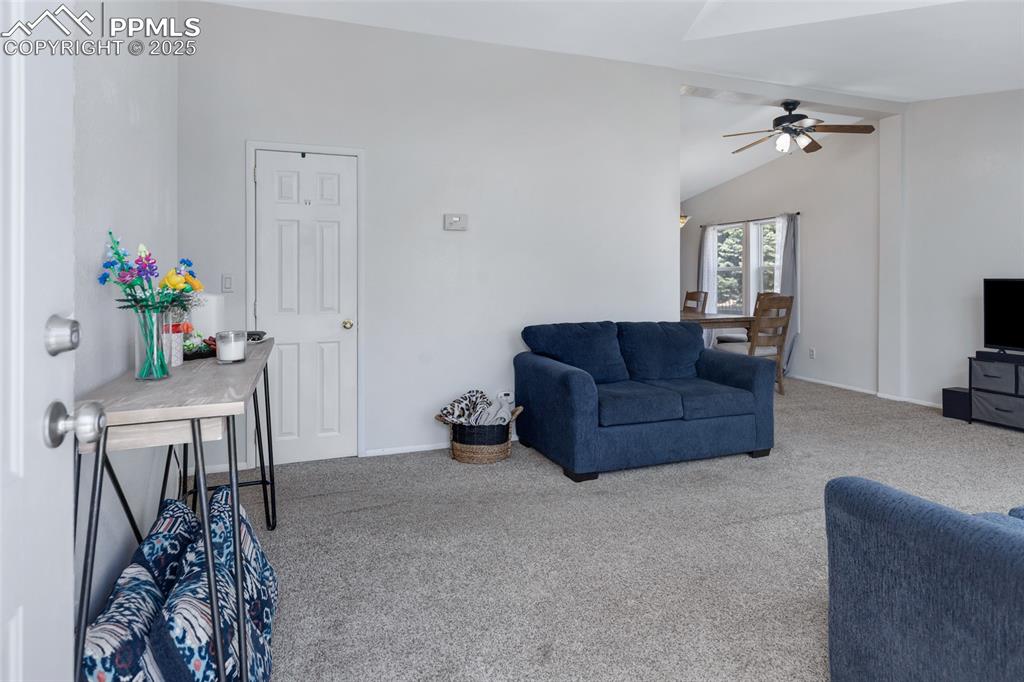 Image 5 of 24: Living room with carpet, lofted ceiling, and a ceiling fan
