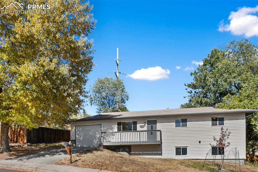 Image 11 of 47: View of front of house featuring a wooden deck, driveway, and a garage