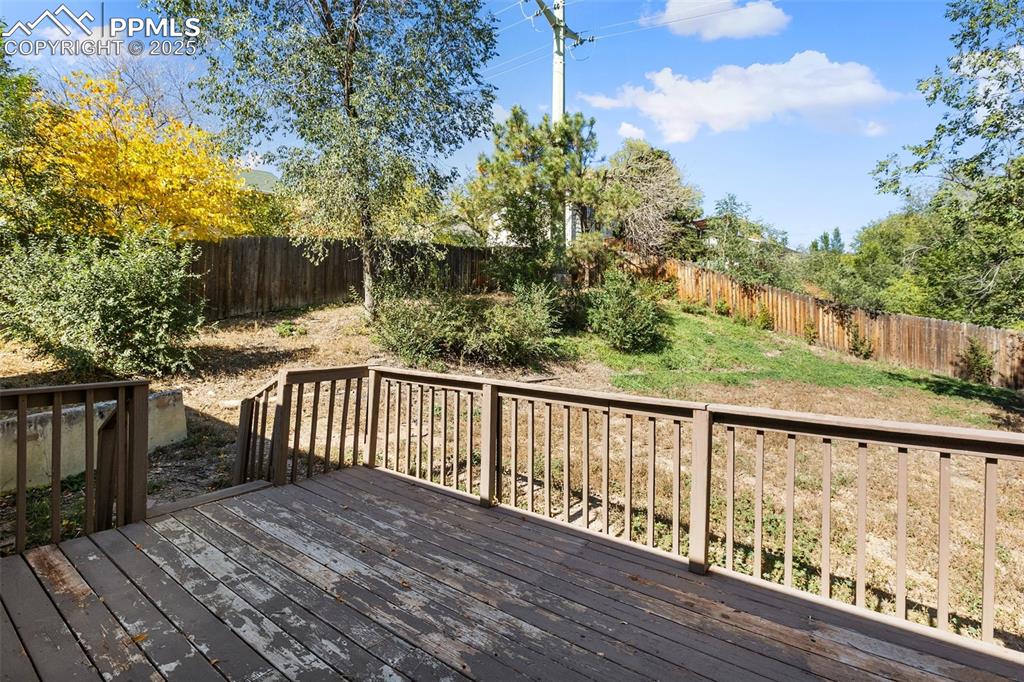 Image 12 of 47: Wooden deck with a fenced backyard