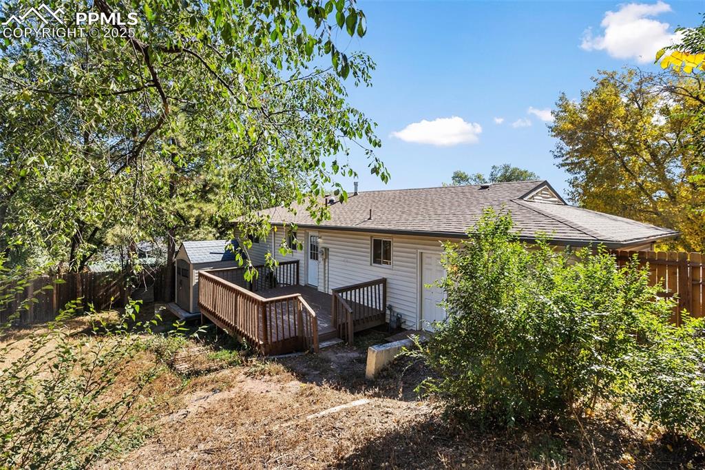Image 13 of 47: Rear view of property with a fenced backyard, roof with shingles, a deck, a