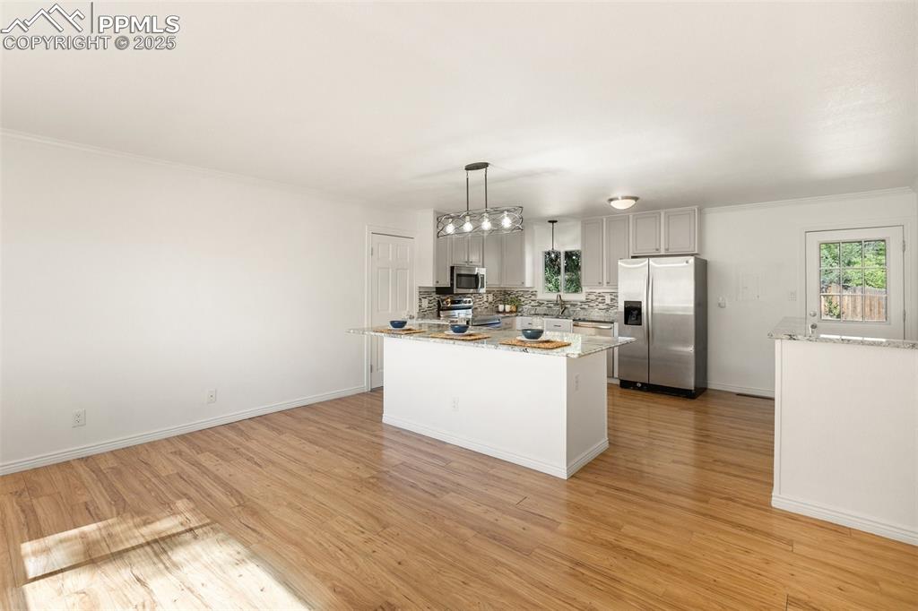Image 14 of 47: Kitchen featuring stainless steel appliances, decorative backsplash, a cent