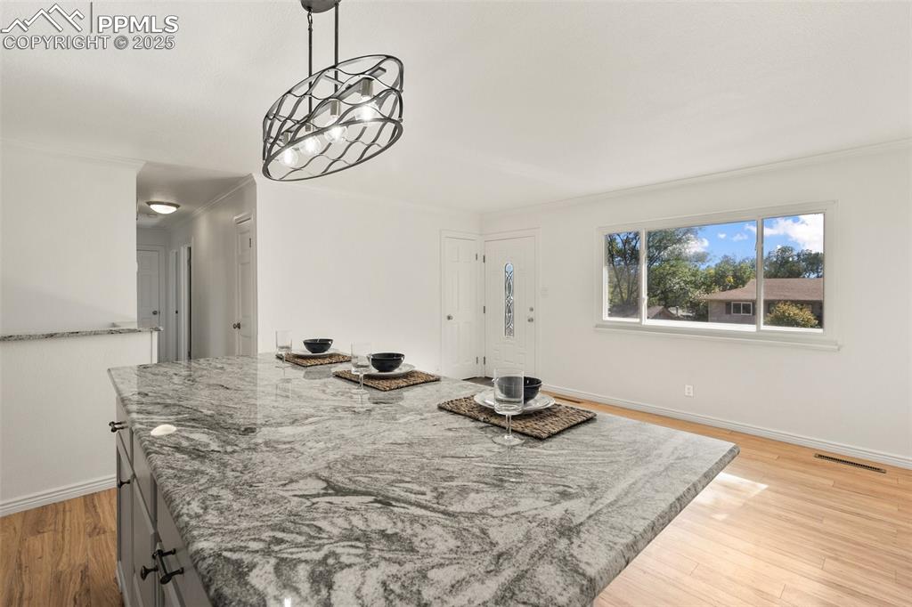 Image 17 of 47: Dining space with light wood-style flooring and crown molding