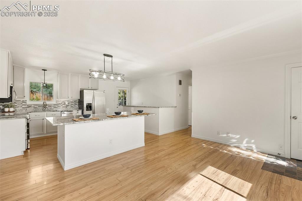 Image 19 of 47: Kitchen with stainless steel appliances, white cabinets, light stone counte