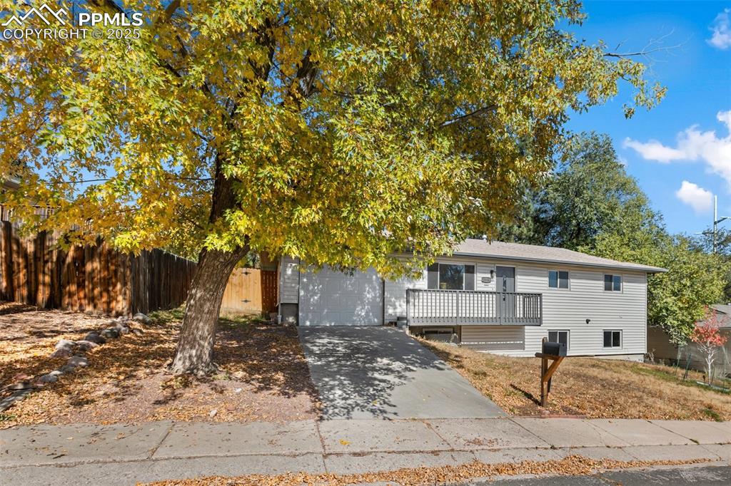 Image 2 of 47: View of front of home with concrete driveway, a garage, and a deck