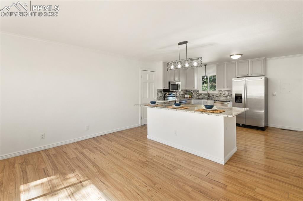 Image 20 of 47: Kitchen with stainless steel appliances, backsplash, pendant lighting, ligh