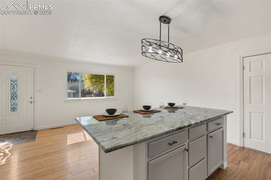 Image 22 of 47: Kitchen featuring light stone countertops, decorative light fixtures, a kit