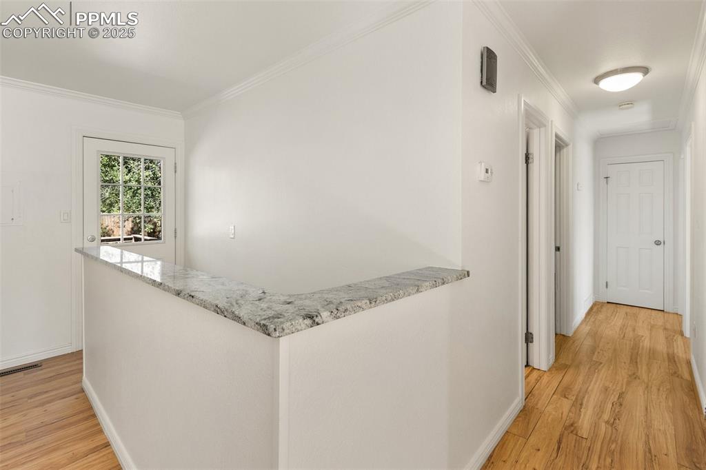 Image 23 of 47: Hall with light wood-style flooring and crown molding