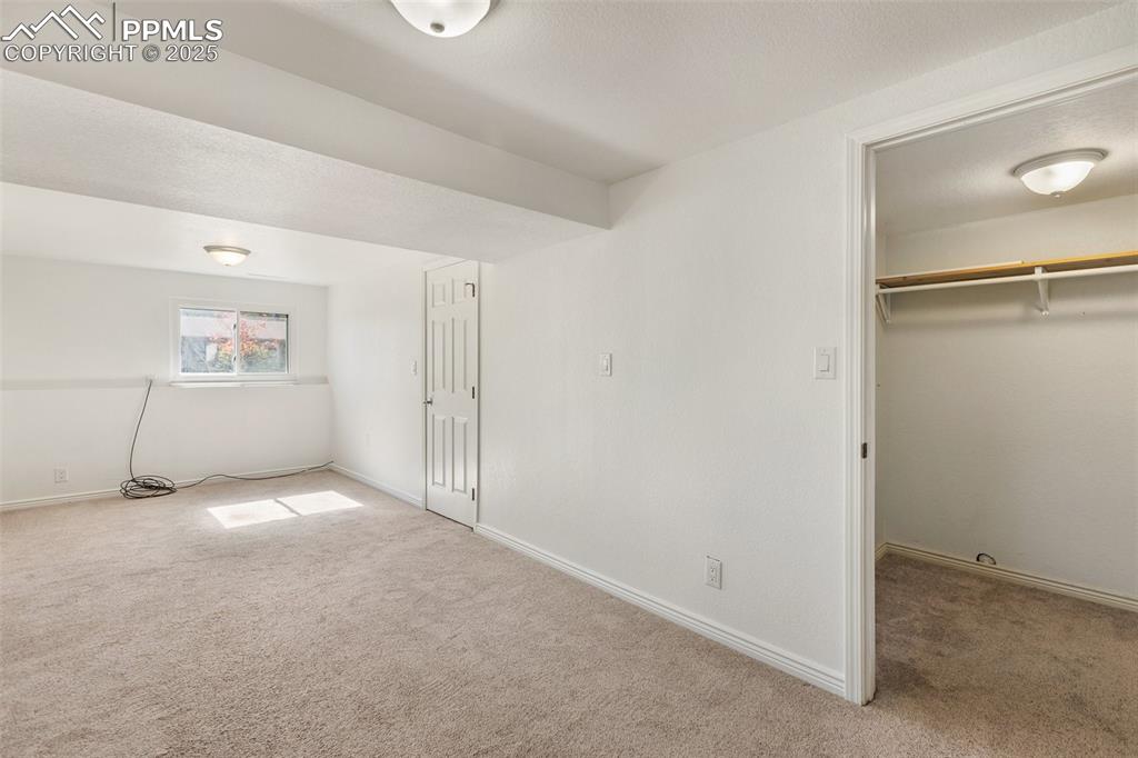 Image 29 of 47: Unfurnished bedroom featuring carpet, a textured ceiling, and a spacious cl
