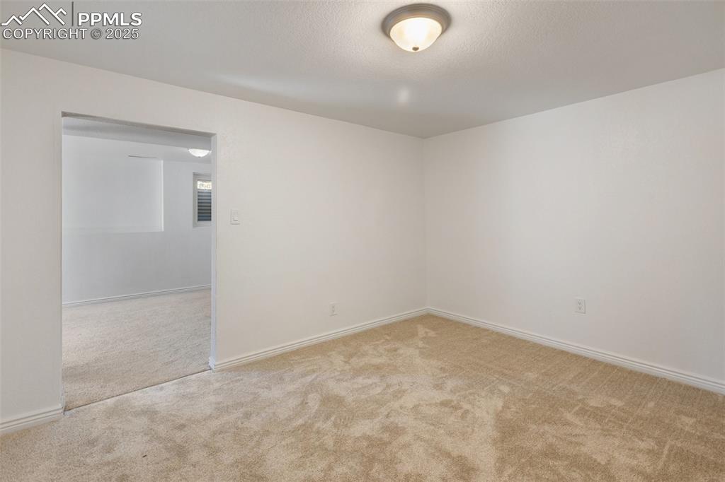 Image 33 of 47: Unfurnished bedroom with light colored carpet and a textured ceiling