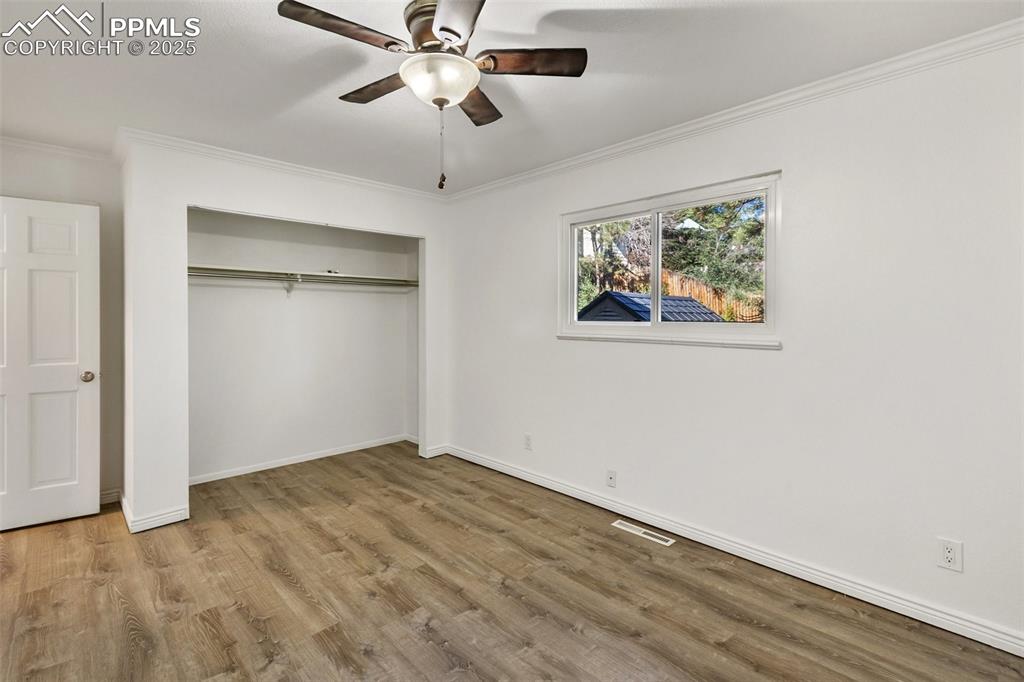 Image 36 of 47: Unfurnished bedroom featuring crown molding, light wood-style flooring, a c