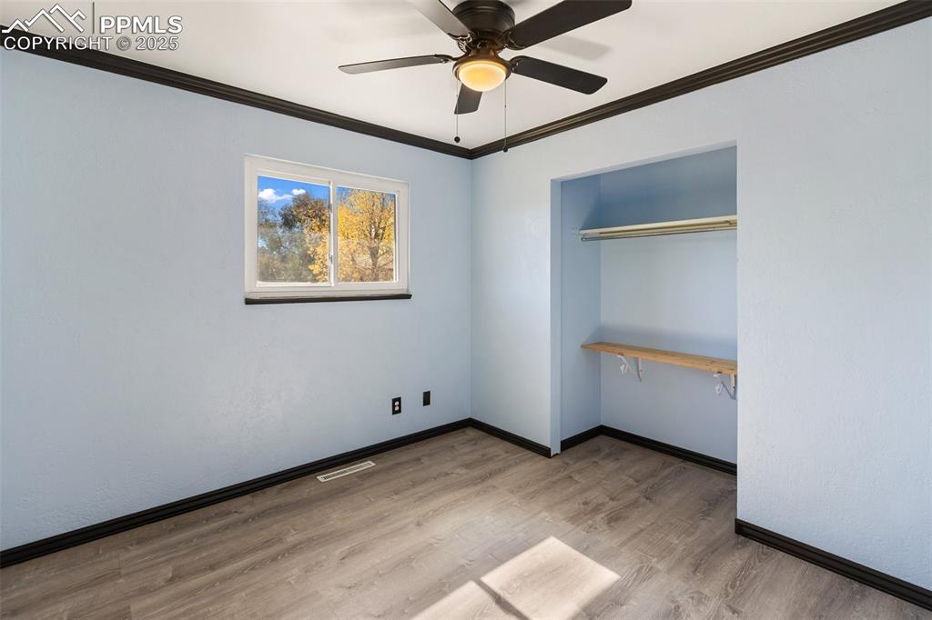 Image 38 of 47: Unfurnished bedroom with ornamental molding, light wood finished floors, a 