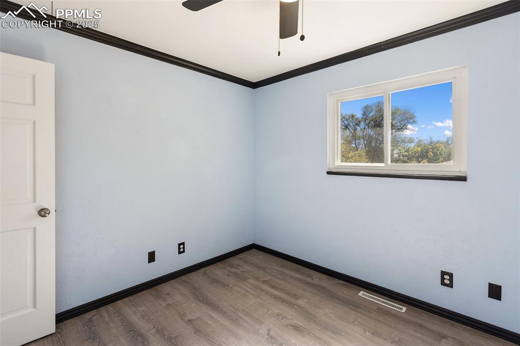 Image 39 of 47: Empty room featuring ornamental molding, wood finished floors, and ceiling 