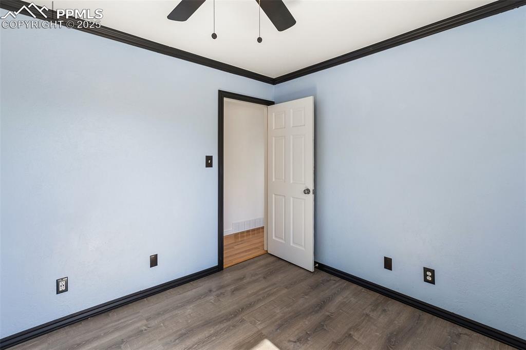 Image 40 of 47: Spare room featuring ornamental molding, wood finished floors, and ceiling 