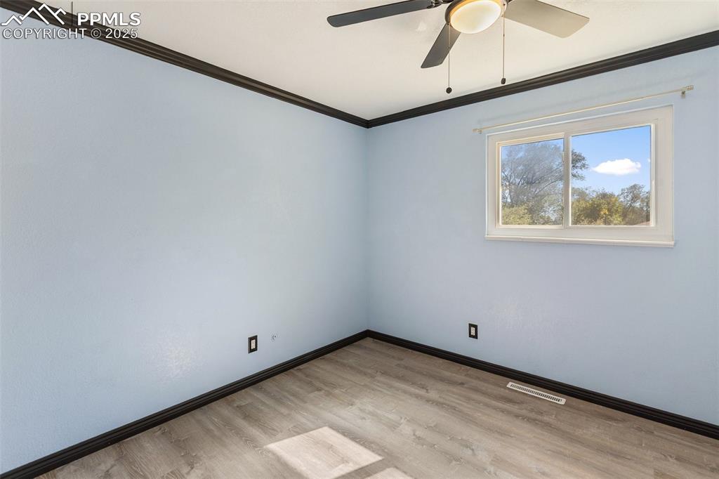 Image 41 of 47: Empty room featuring crown molding, light wood finished floors, and ceiling