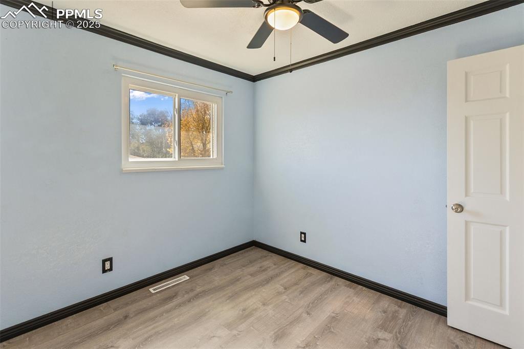 Image 42 of 47: Spare room with ornamental molding, light wood finished floors, and ceiling