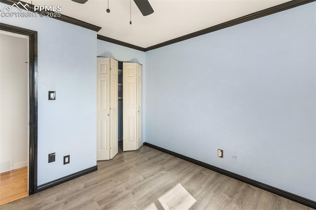 Image 43 of 47: Unfurnished bedroom with ornamental molding, light wood-type flooring, ceil