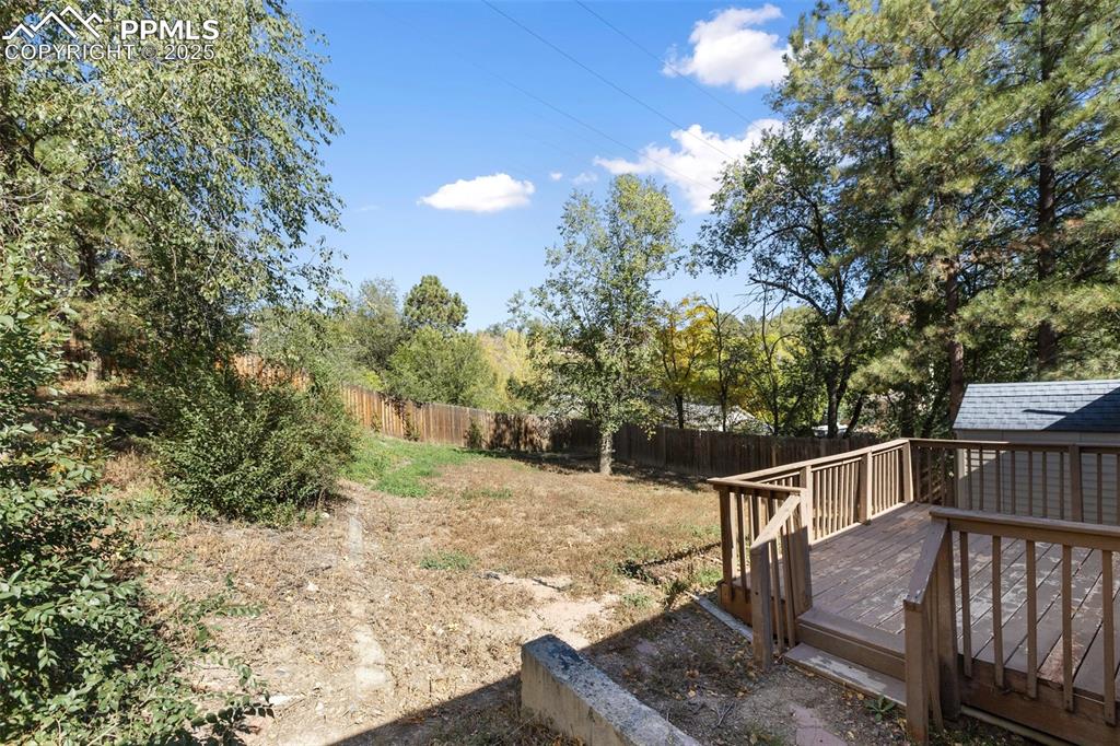 Image 47 of 47: Fenced backyard with a storage shed and a deck