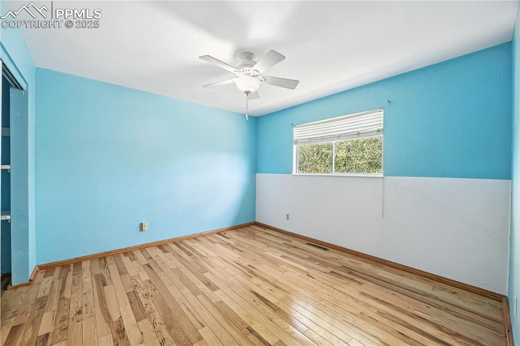 Image 11 of 23: Spare room featuring hardwood / wood-style floors and ceiling fan