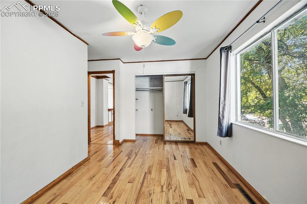 Image 14 of 23: Unfurnished bedroom with light wood-style floors, ornamental molding, ceili