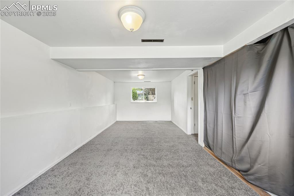 Image 17 of 23: Empty room with carpet and baseboards