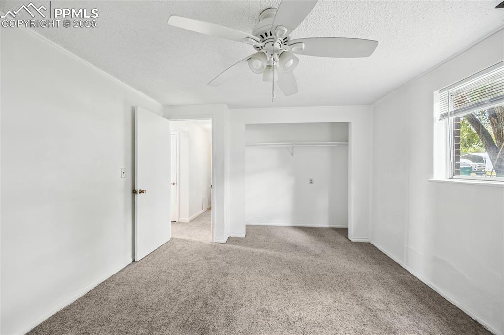 Image 19 of 23: Unfurnished bedroom with carpet floors, a textured ceiling, a ceiling fan, 