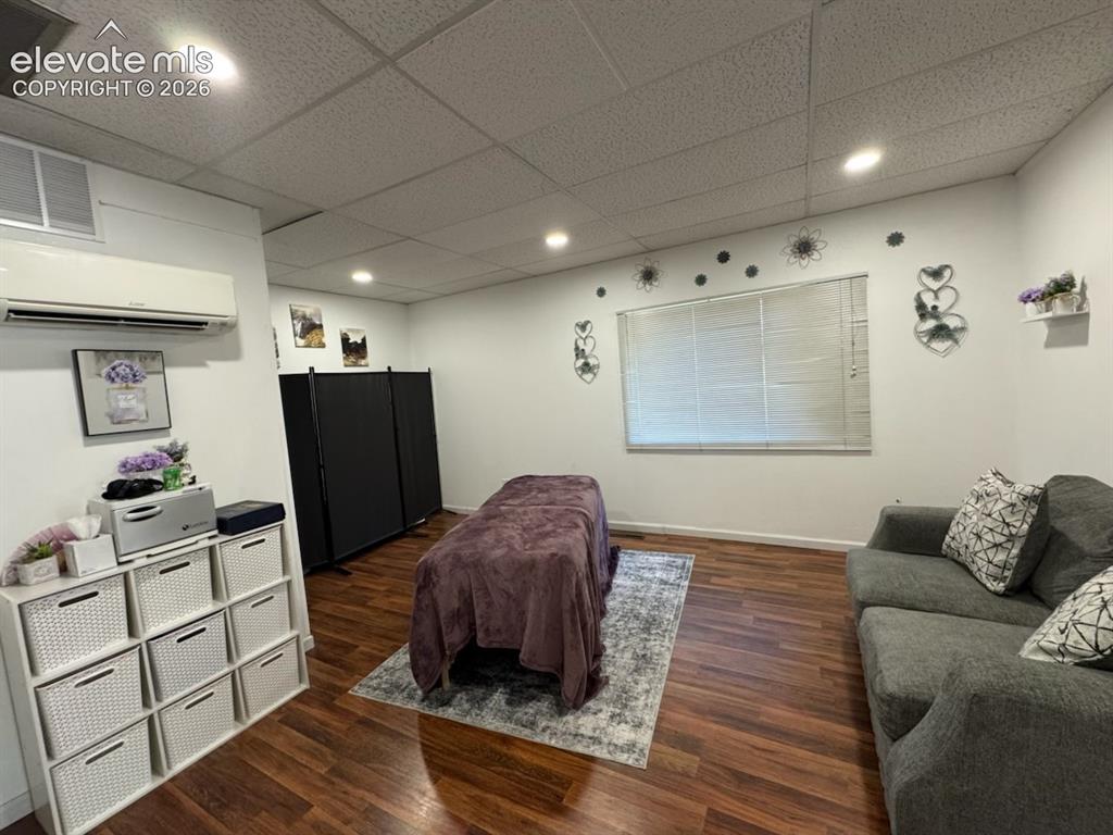 Image 16 of 27: Recessed lighting, wood-finish flooring, drop ceiling, window with blinds, 
