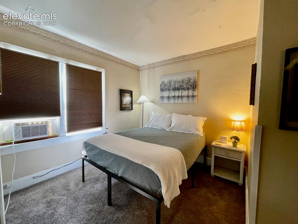 Image 2 of 27: Textured wall-to-wall carpeting, dual windows with privacy blinds, and deco