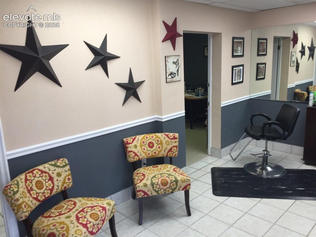 Image 20 of 27: Tiled flooring, two-tone wall paint, built-in wall mirror, and an open door