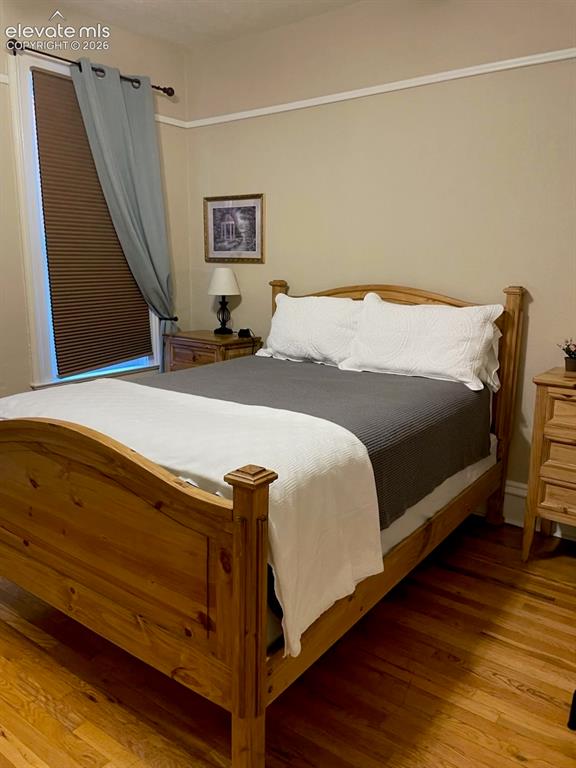 Image 21 of 27: Hardwood flooring, painted walls, crown molding, and a window with blinds