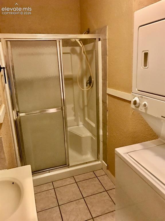 Image 3 of 27: Walk-in shower with sliding glass enclosure, integrated seating, and a hand