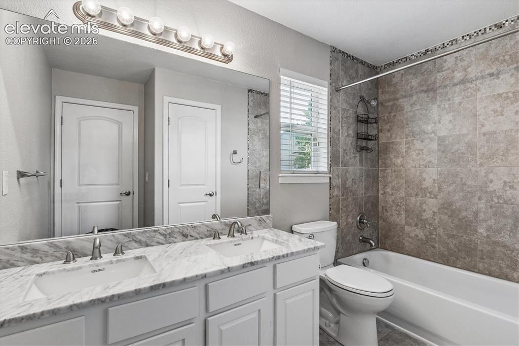 Image 26 of 46: Upper floor bathroom with dual vanity, shower/tub combination and linen clo