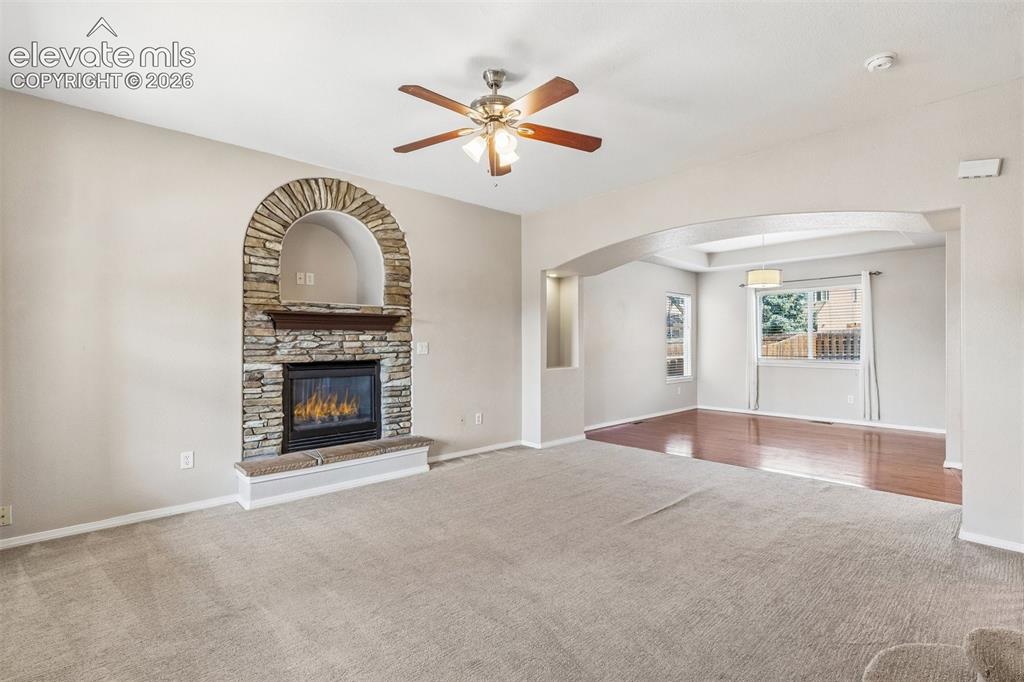Image 6 of 46: Living room with gas log fireplace open to formal dining room